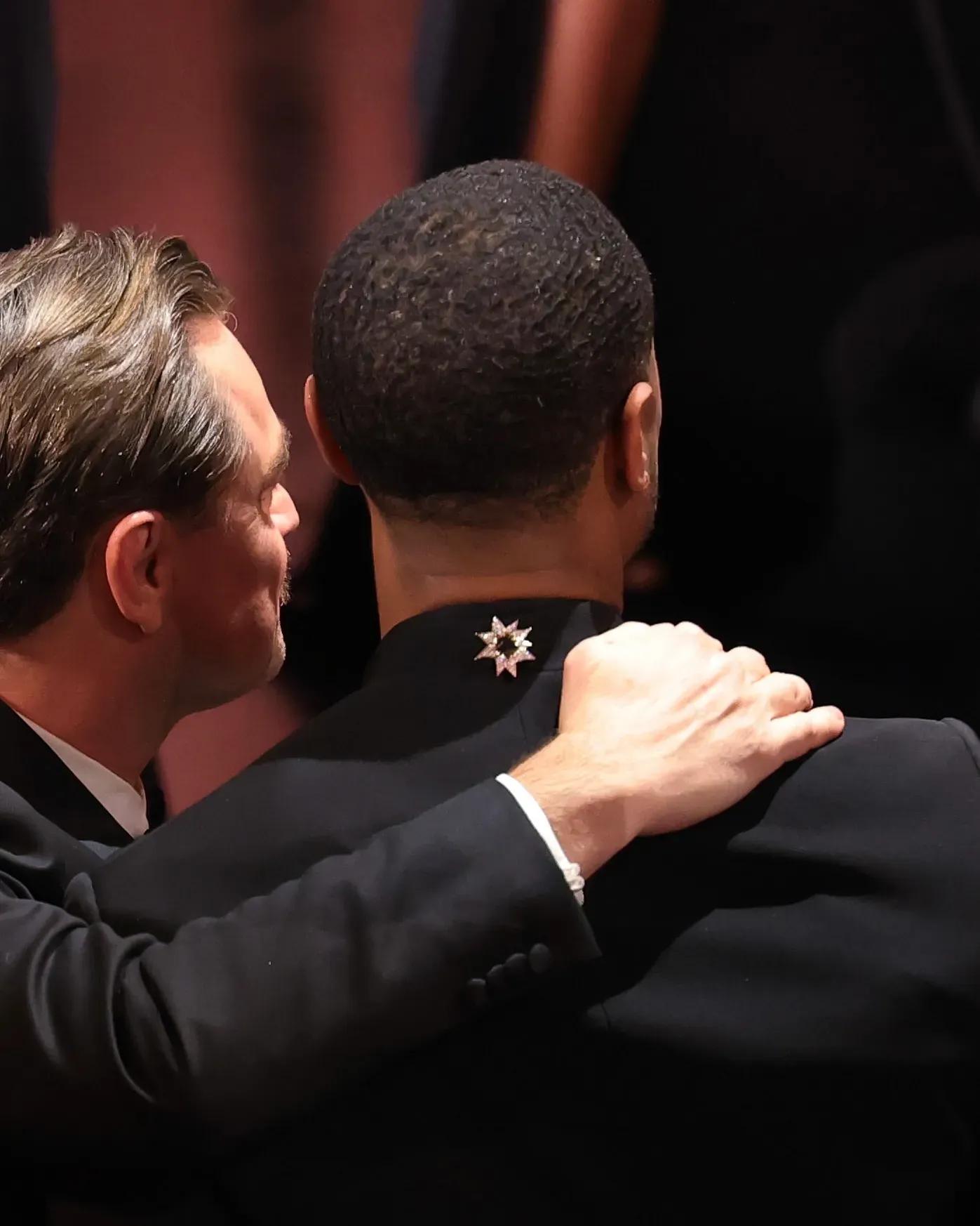 Michael B. Jordan wearing a brooch on the back of his jacket at the Oscars 2026 red carpet