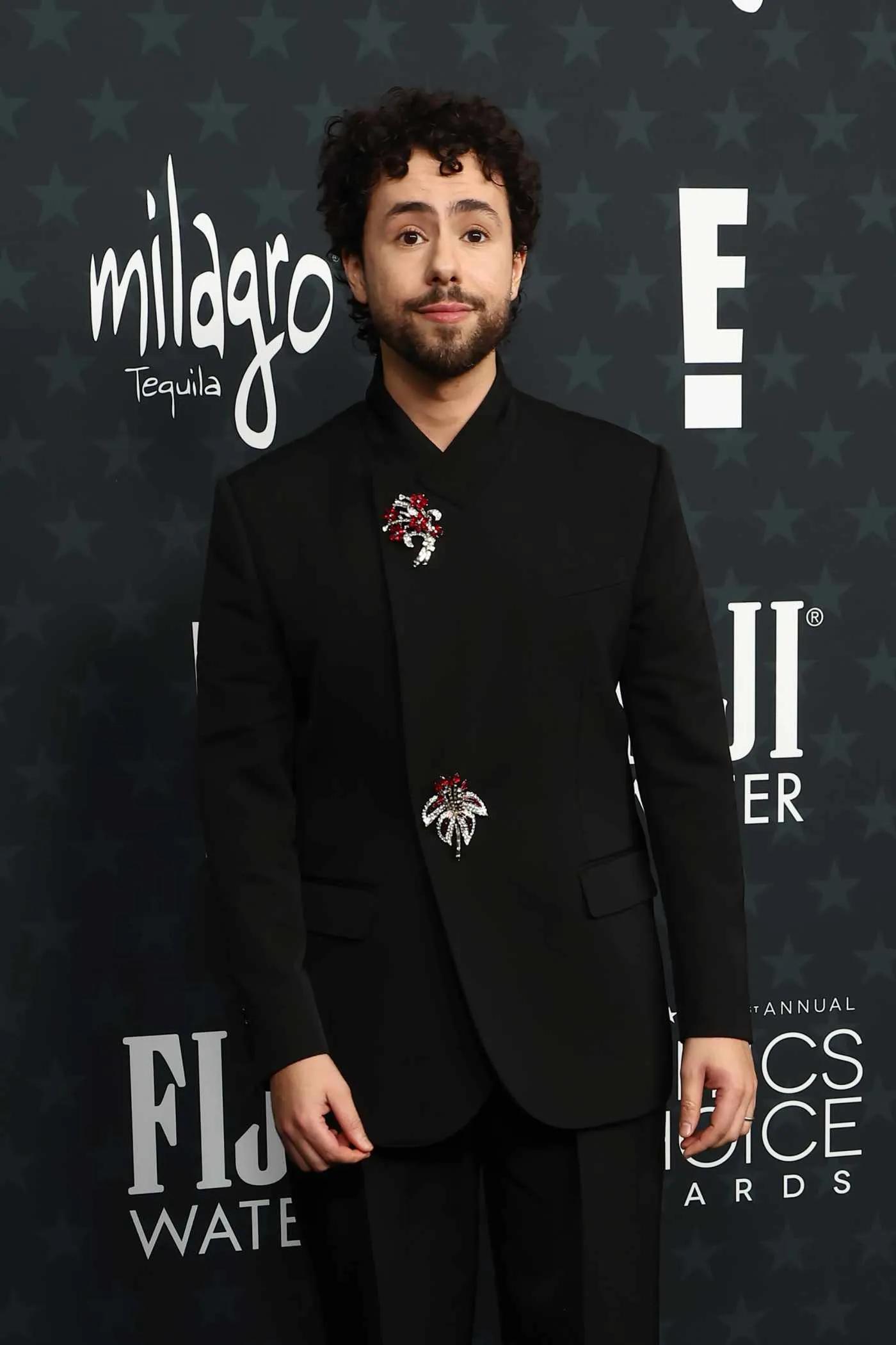 Ramy Youssef wearing brooches as buttons at the Critics’ Choice Awards 2026